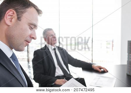 Close-up portrait of thougtful business man at meetig in office