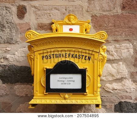 old yellow German Mailbox hanging on the wall