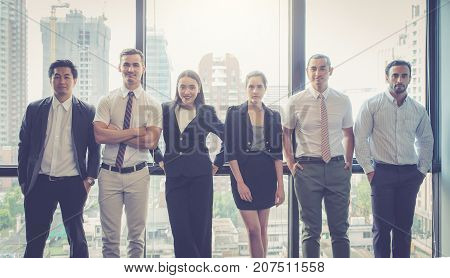 Portrait of happy business partners looking at camera with smiles and geture of teamwork.