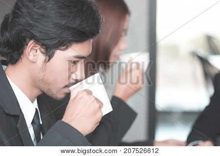 Businesswoman drinking coffee / tea and using tablet computer in a coffee shop