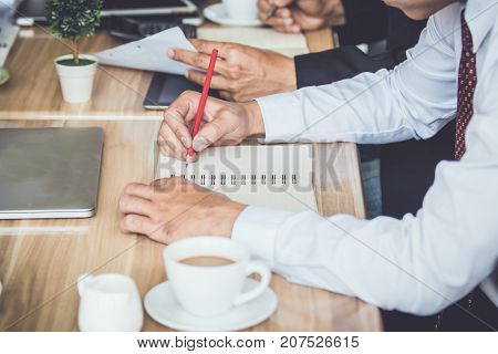 Businessmen use a pencil point to business document during discussion at meetingVintage filters