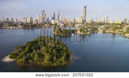 Aerial view of Girung Island and Surfers Paradise cityscape with waterfront properties on the canals.