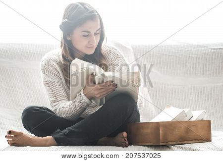 Girl Reading Book On Sofa