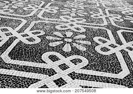 Traditional style Portuguese pavement designed with black and White stones of basalt and limestone used in pedestrian areas of Portugal