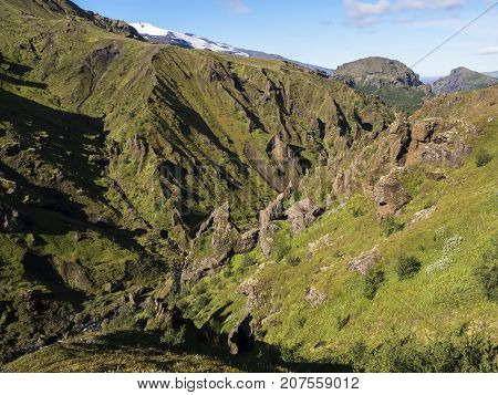 Gorge overgrown with bright green moss in the mountains of Iceland