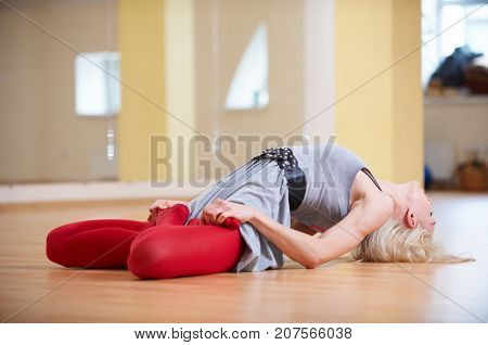 Beautiful sporty fit yogi woman practices yoga asana Matsyasana - Fish pose in the yoga class