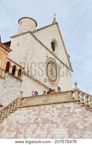 ASSISI ITALY 30 JUNE 2017: Famous Basilica of St. Francis of Assisi (Basilica Papale di San Francesco) with Lower Plaza at sunset in Assisi Umbria Italy