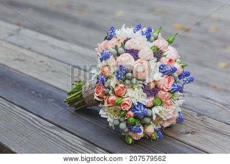 Bridal bouquet with roses brunia and Muscari flowers. Traditional accessory for wedding.