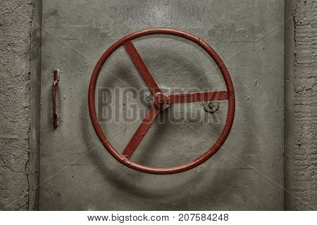 Closed hermetic door with red handweel of old soviet bunker