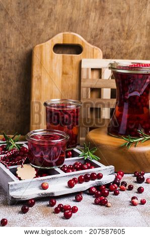 Cranberries with the syrup in glass on wooden background. Selective focus.
