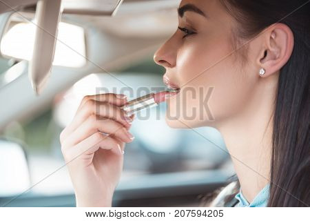 Woman Applying Lipstick In Car