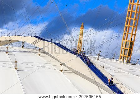 A Group Of People Climbing The Top Of O2 Dome In North Greenwich