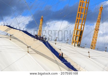 A Group Of People Climbing The Top Of O2 Dome In North Greenwich