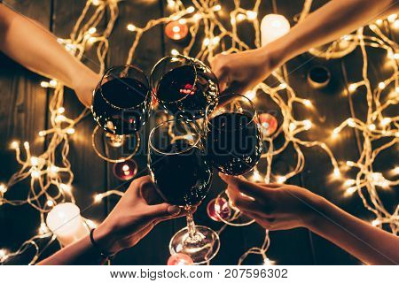 People Clinking Glasses Over Fairylights