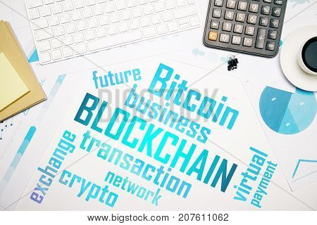 Top view of white office desktop with blockchain text. Bitcoin cocnept