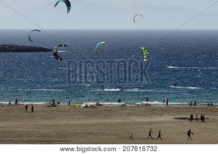 Sandy beach and the kitesurfers on the waves of the Aegean sea at Prasonisi (Greece)