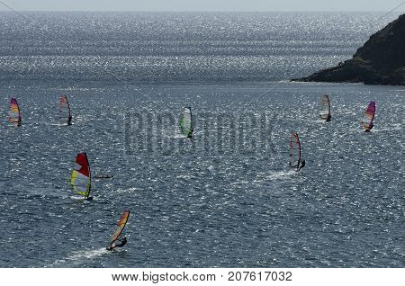 Windsurfers on the sparkling waves of the Mediterranean sea at Cape Prasonisi (Greece)