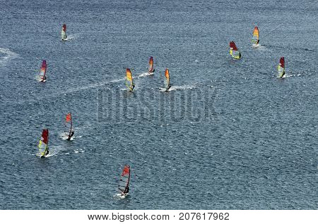 Many windsurfers on the sparkling waves of the Mediterranean sea at Cape Prasonisi (Greece)