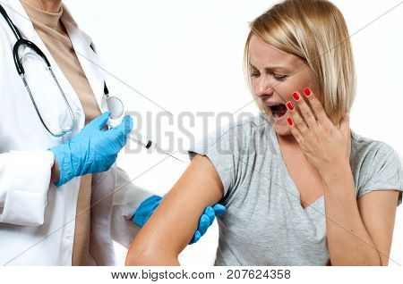 Vaccination. Doctor injecting flu vaccine to patient's arm. Doctor making woman an injection