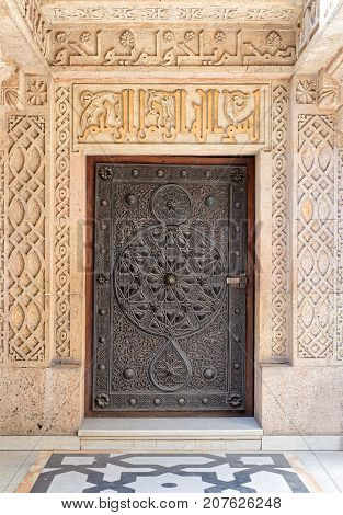 Closed wooden aged door with ornate bronzed floral patterns at the mosque of The Manial Palace of Prince Mohammed Ali Tewfik Cairo Egypt
