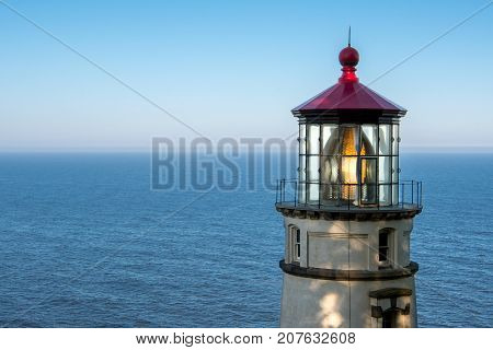 Lantern Reflects in Heceta Head Lighthouse with calm Pacific ocean in background