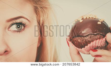 Woman Holding Chocolate Cupcake About To Bite