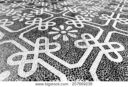 Traditional style Portuguese pavement designed with black and White stones of basalt and limestone used in pedestrian areas of Portugal