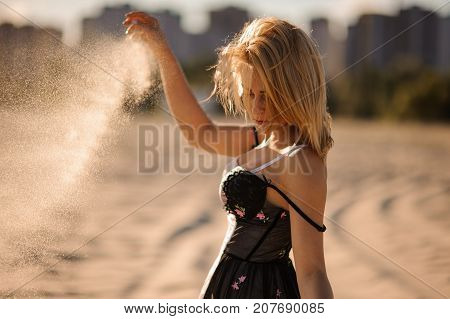 Tender   shot of sexy and beautiful blond woman in lingerie with sand in hands