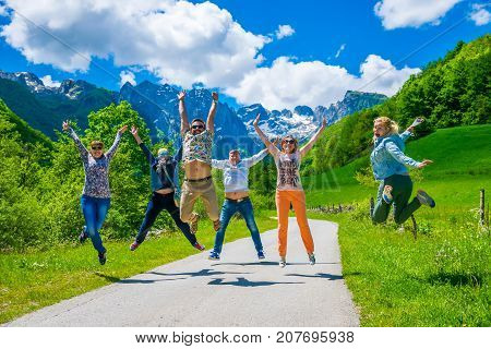 Montenegro, Prokletije Mountains - May 29/2017: Tourists Joyfully Jump Up Against The Background Of
