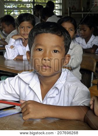 Seam Reap, Cambodia: October 08, 2012: Close up of a Cambodian school boy at his desk. The school is named New Bridge for Cambodia and is an organization that offers students free education.
