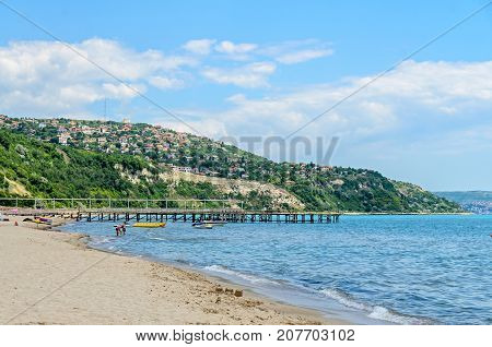 ALBENA BULGARIA - JUNE 16 2017: The Black Sea shore green hills with houses blue clouds sky. City Balchik coast.