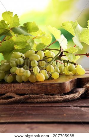 Grapes on wooden table and grape leaves . Healthy fresh fruit wine grapes.