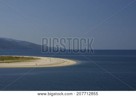 Keramoti beach with blue sky and Thassos Island with Ipsarion mountain in background picture from Thassos Island Greece.