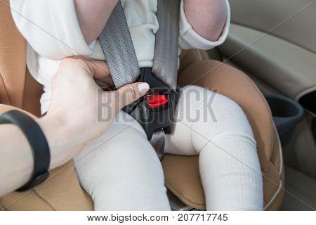 Child In A Baby Car Seat. Isofix Clamping. Beige Car Seat In A Bright Salon