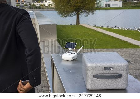 Young hipster man with drone equipment near a lake