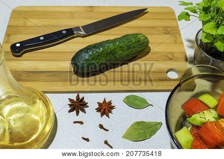 Cut cucumber with a knife on a bamboo board
