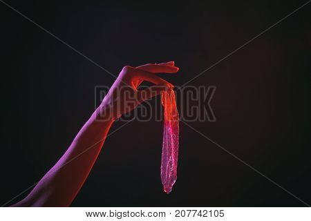 Condom Contraception. Girl Holding Condom In Beautiful Erotic Evening Light. Sexy Evening For Young