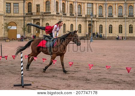 Gatchina St. Petersburg Russia - September 30 2017: Horse show of Cossacks on the parade ground of the Gatchina Palace. Young Cossack performs tricks on horseback.