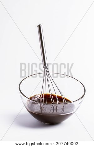 whisk, bowl with chocolate on a white background