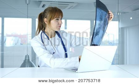 Young Female Serious Doctor Examing X-ray Of Patient, Lungs And Ribcage