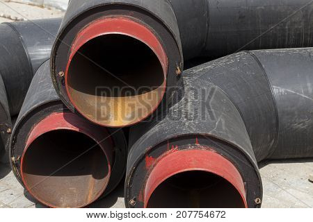 Large Diameter Wide Metal Pipes Covered With A Thick Layer Of Black Rubber. Close-up Photo During Se