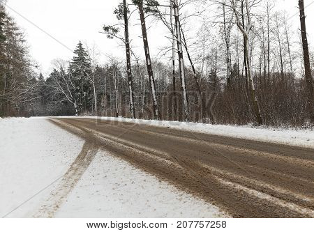 Car Paved Road, Where The Snow Melted. On The Snow Prints Of The Car Wheels Visible. On The Side Of 