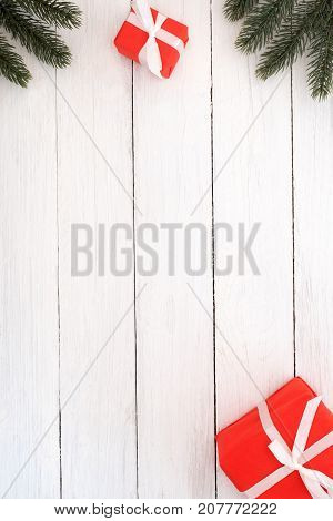 Christmas and New Year background. Christmas red gifts boxes and fir leaves with decoration rustic elements on white wood background. Creative flat lay top view design