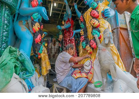 KUMARTULI KOLKATA INDIA - OCTOBER 10 2014 - Artist preparing clay idol to be worshipped as Goddess Kali during Kali Puja Hindu festival of Deepavali or Diwali. Celebtated all over India.