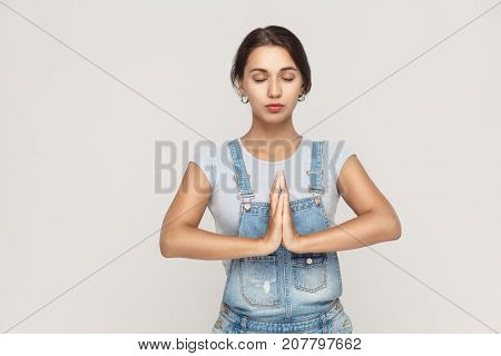 Beautiful Young Caucasian  Female, Holding Hands In Namaste Or Prayer, Keeping Eyes Closed While Pra