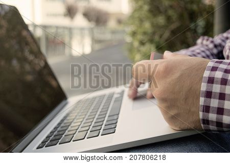 man holding credit card and laptop staying outside and paying or buying online self-employed businessman online business