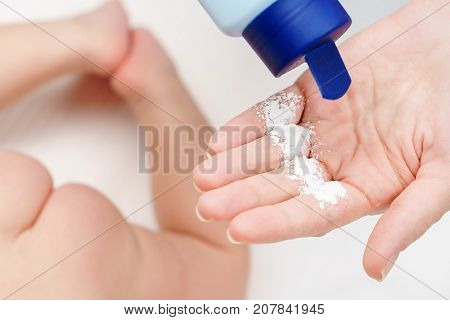 Mom Applying Talc Powder From Plastic Tube To The Baby Body