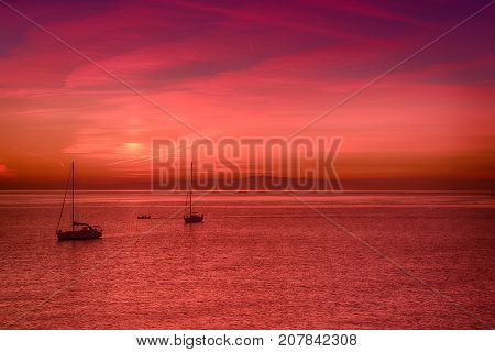 Beautiful colorful sunset at the sea with two sailing boats . Beauty world natural outdoors travel background