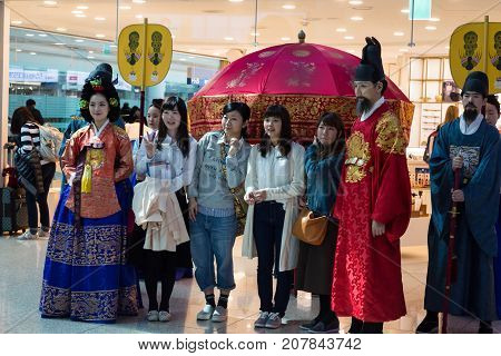 March 8 2016: South Korea Incheon International Airport. Korean national concert historical costume parade of the royal family Joseon Dynasty. Presentation of national traditions. Passengers make photos with artists