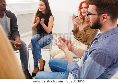 Meeting of support group. Company of people sitting in circle and clapping to speaker, psychotherapy background